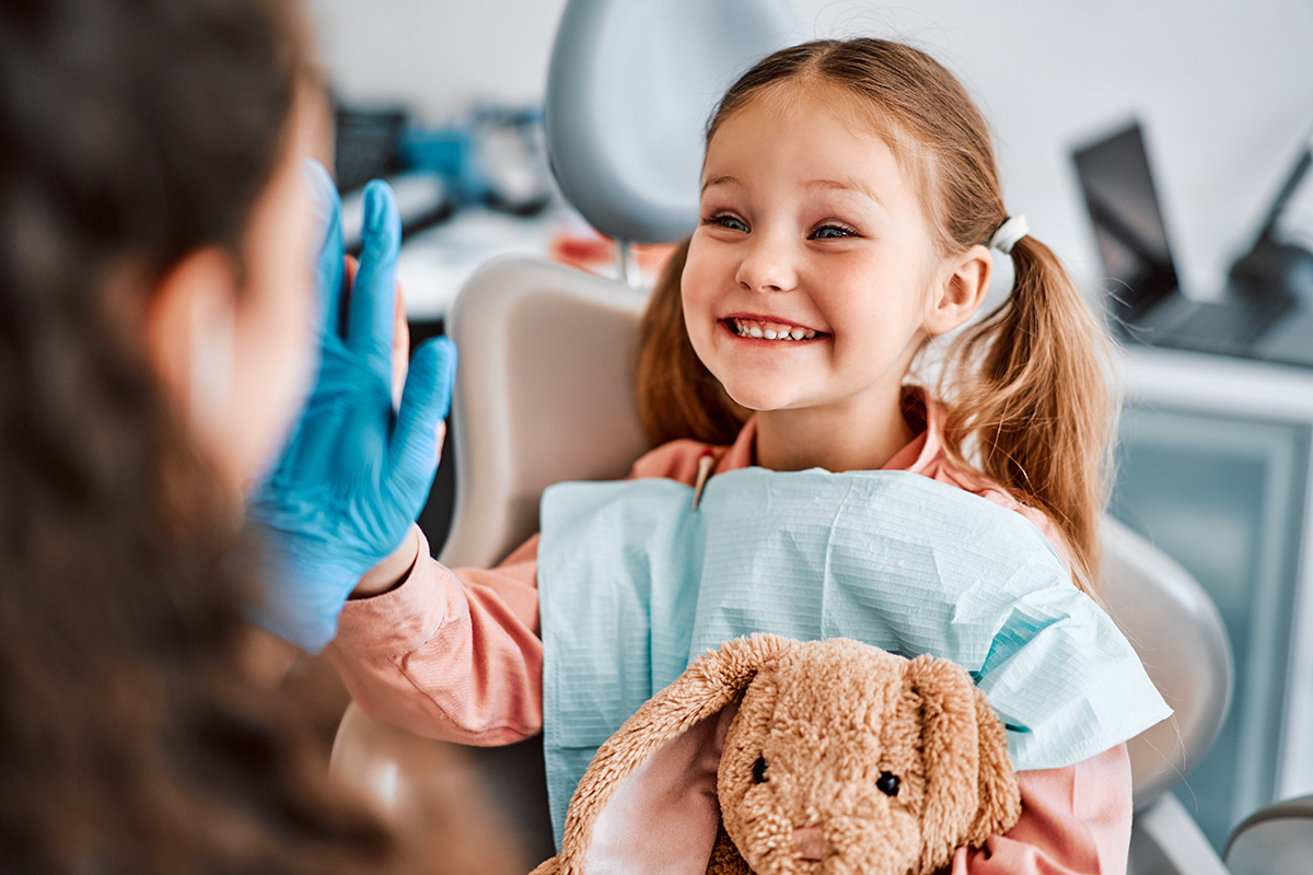 toddler with baby teeth visiting a pediatric dentist